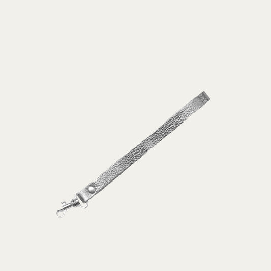 A silver metallic wristlet strap attachment with silver hardware on a white background.